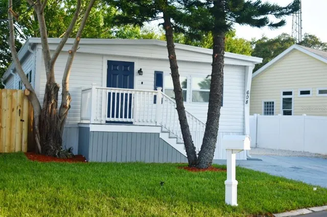 a view of backyard with a deck and a large tree