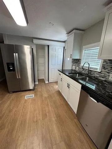 a kitchen with granite countertop a sink and a stove top oven