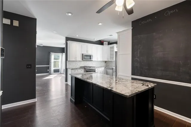a kitchen with granite countertop a sink stove and refrigerator