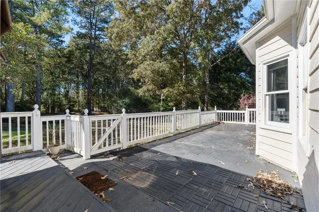 a view of a patio with table and chairs with wooden floor and fence
