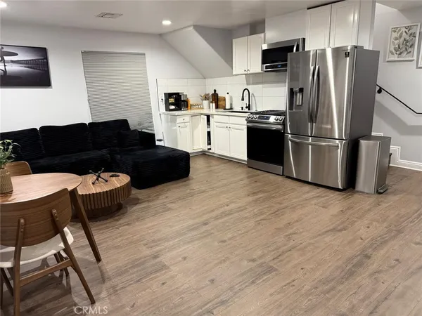 a kitchen with stainless steel appliances kitchen island hardwood floor sink and stove
