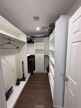 a view of walk in closet with clothes and shoes