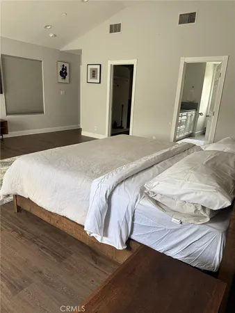 a bedroom with a bed and painting on the wall