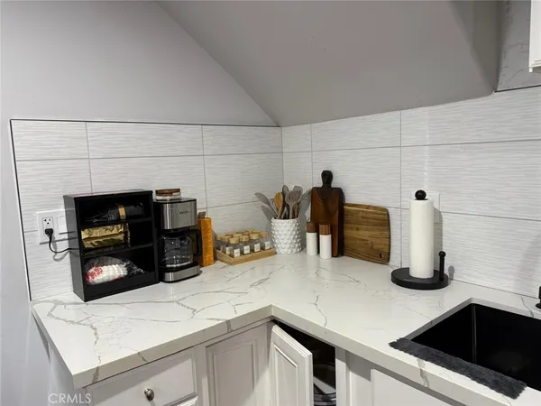 a kitchen with a sink and white cabinets