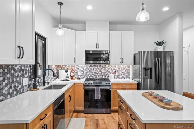 a kitchen with stainless steel appliances kitchen island granite countertop a sink stove and refrigerator