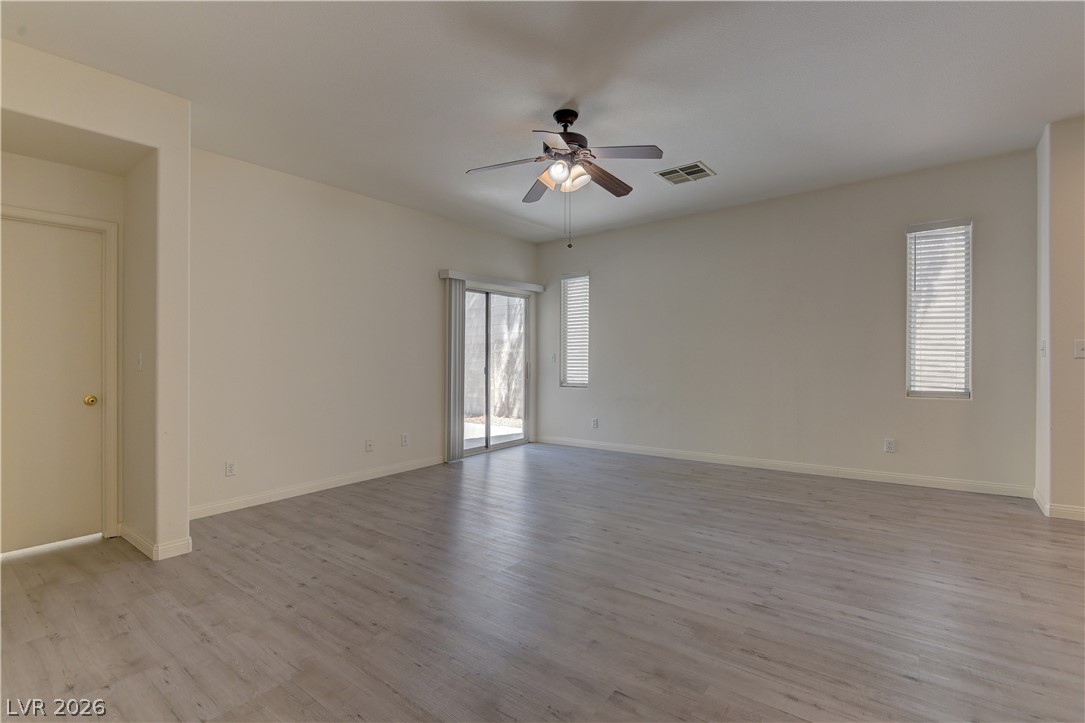 4613 Rising Cove Street Las Vegas, NV 89129 - Photo 5 of 20 Bright and airy living area with modern flooring and outdoor access.
