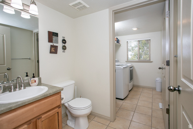 426 Deer Hollow Road Tooele, UT 84074 - Photo 11 of 37 Bathroom with light tile patterned floors, washing machine and clothes dryer, and vanity