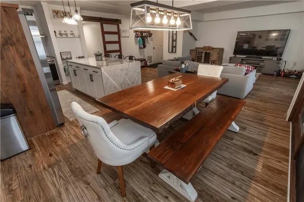a living room with furniture a flat screen tv and floor to ceiling window