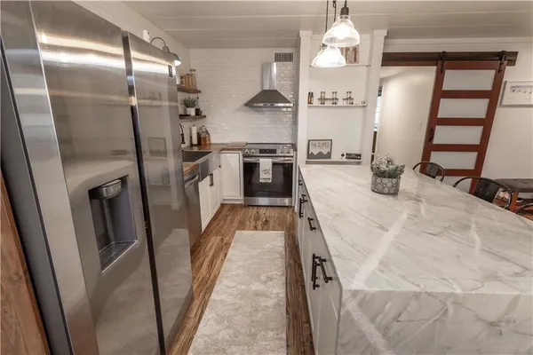 a kitchen with stainless steel appliances granite countertop a refrigerator a oven a sink and dishwasher