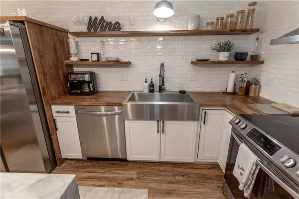 a kitchen with stainless steel appliances a stove a refrigerator and wooden cabinets