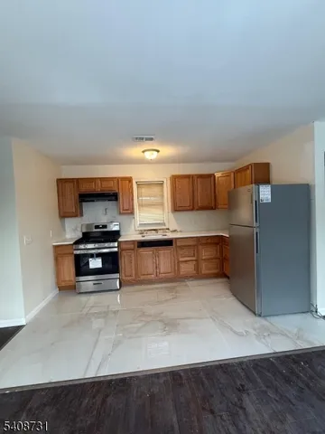 a kitchen with stainless steel appliances a refrigerator and a stove top oven