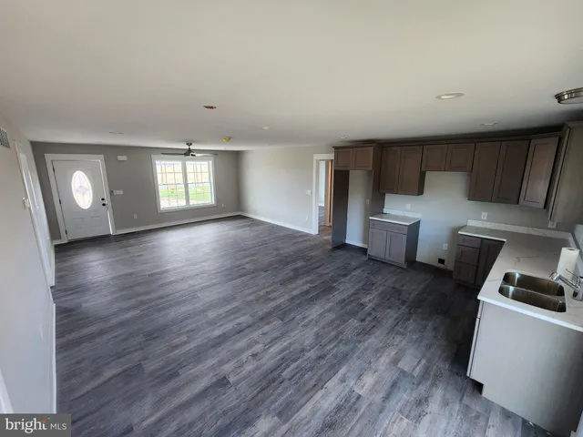 a view of a livingroom with wooden floor and a sink