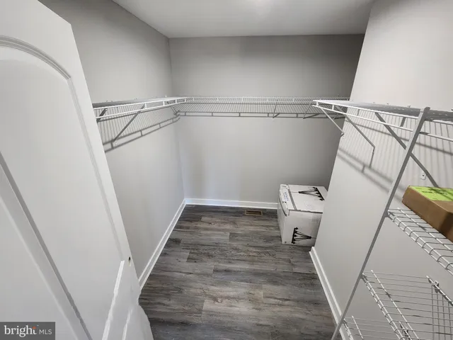 a view of walk in closet with wooden floor
