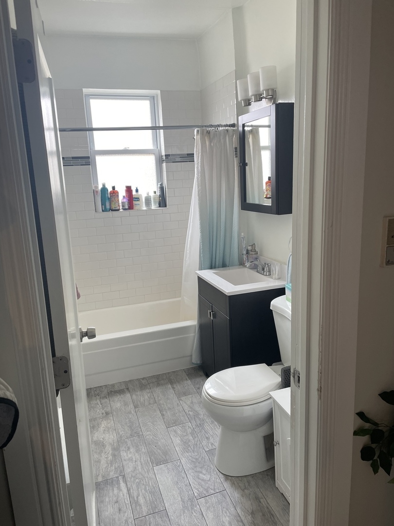 730 West Roscoe Street, Unit 2S Chicago, IL 60657 - Photo 13 of 15 a bathroom with a toilet sink and mirror