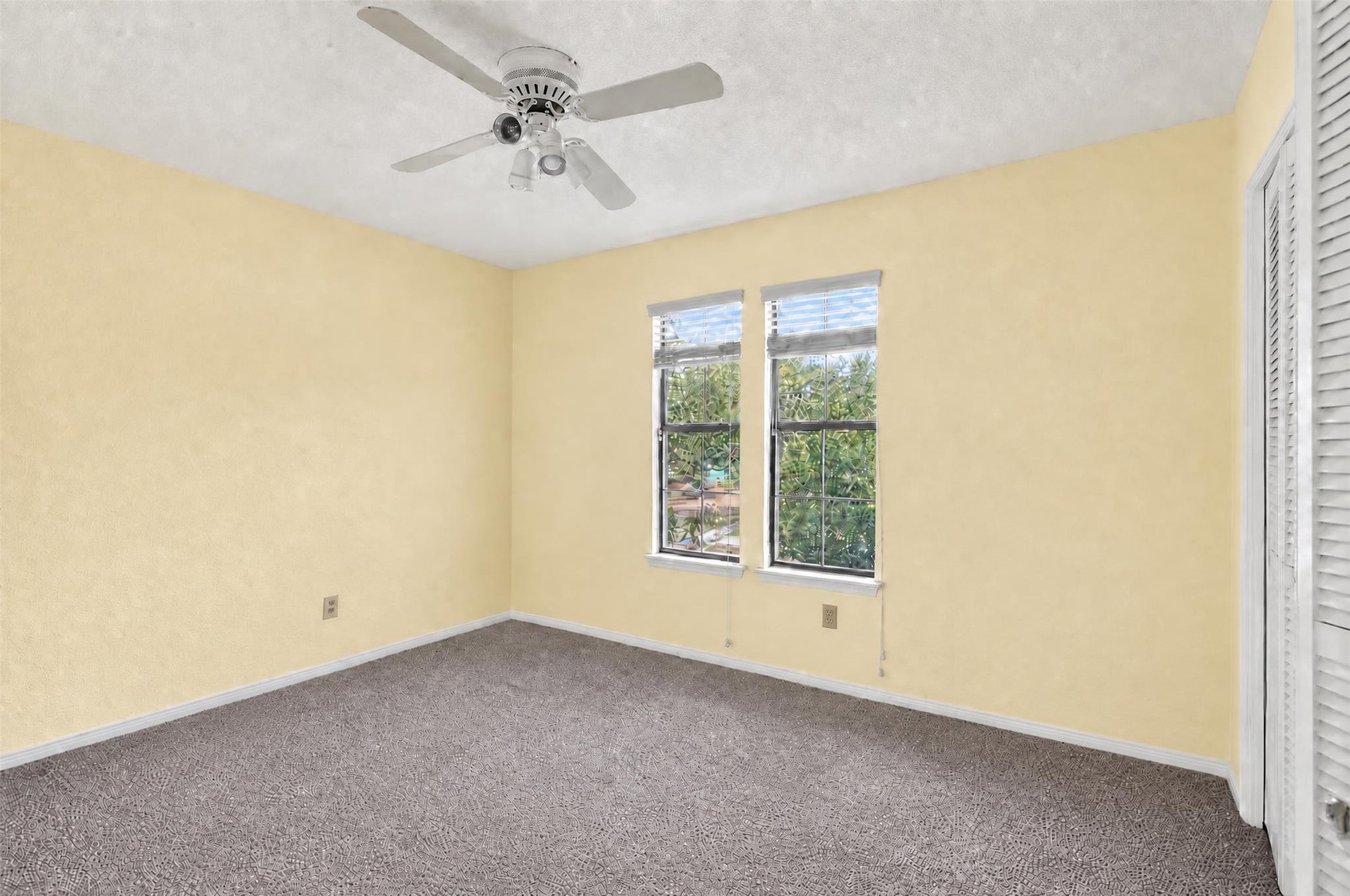 7019 Wyoma Trail Spring, TX 77379 - Photo 24 of 34 Bright bedroom with plush carpet, and a ceiling fan. Large windows offer ample natural light and a view of lush greenery.