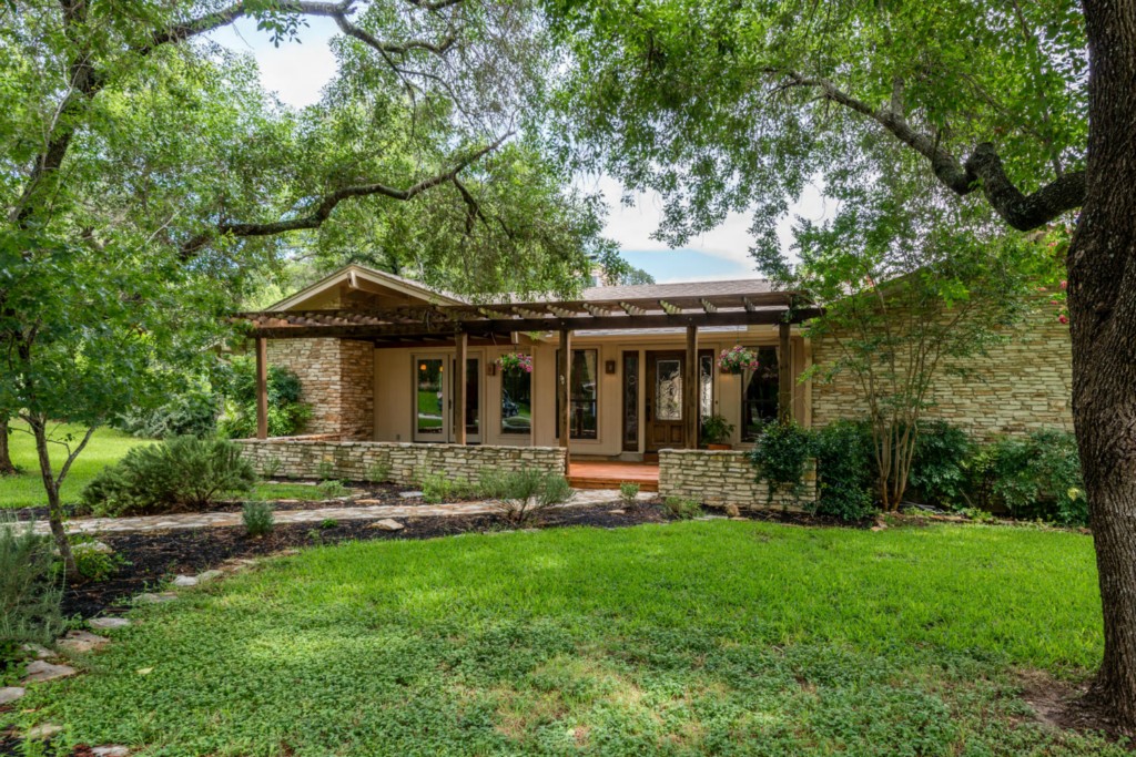 700 Grey Fox Trail Austin, TX 78746 - Photo 1 of 1 a front view of a house with a yard table and chairs
