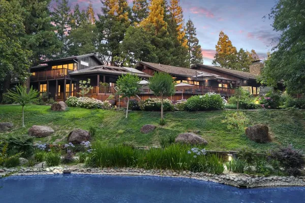 a view of a house with backyard sitting area and garden