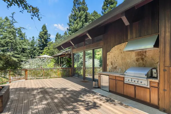 a backyard of a house with table and chairs under an umbrella