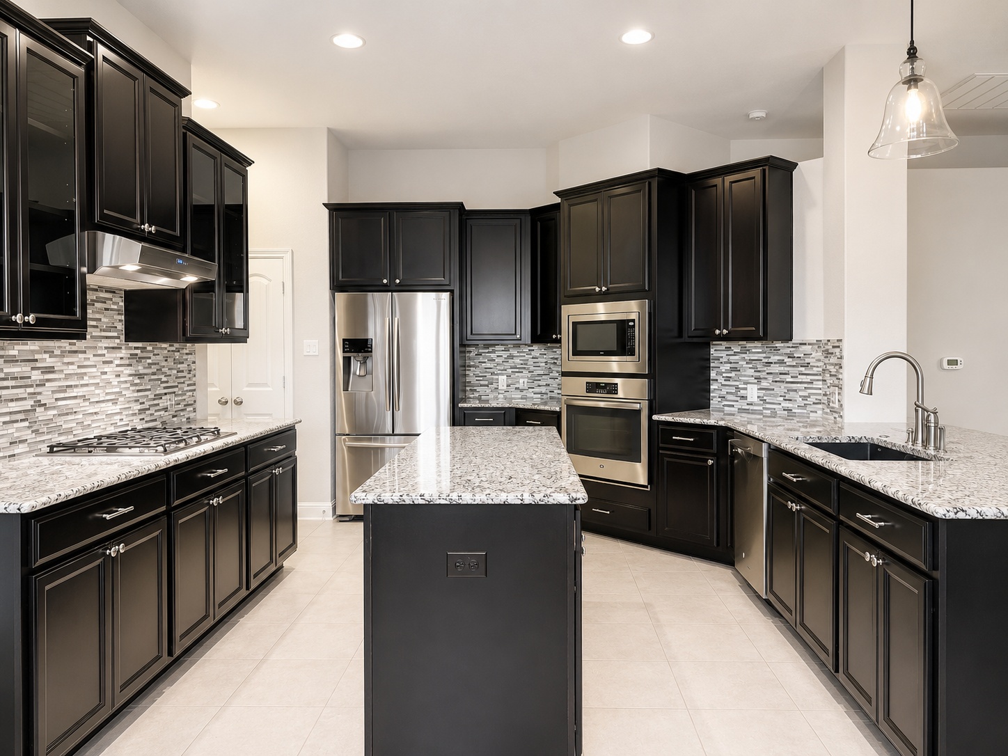 18512 Rio Chama Lane Austin, TX 78738 - Photo 12 of 20 Granite countertops and dark cabinetry define this spacious, modern kitchen with tile flooring.