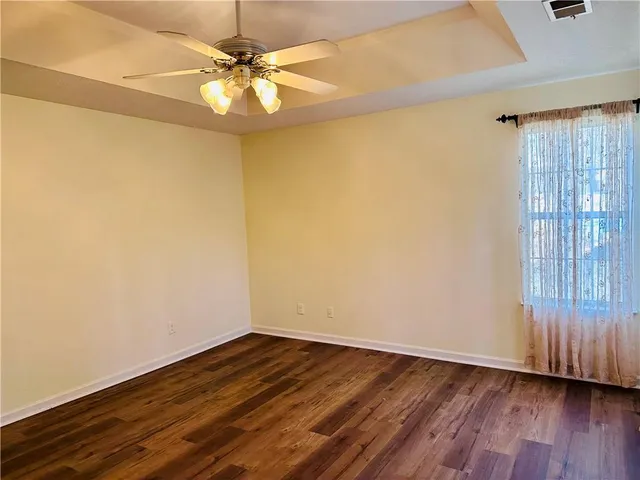 a view of a room with wooden floor and a ceiling fan