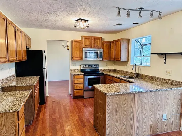 a kitchen with stainless steel appliances granite countertop a sink stove and refrigerator