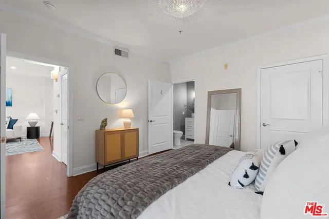 a spacious bedroom with a bed and a chandelier