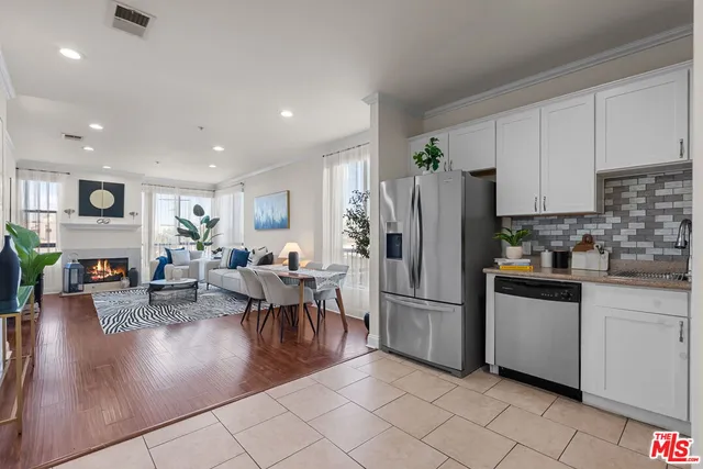 a kitchen with stainless steel appliances granite countertop a refrigerator dining table and chairs
