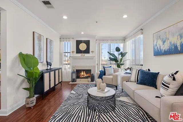 a living room with furniture a fireplace and a potted plant