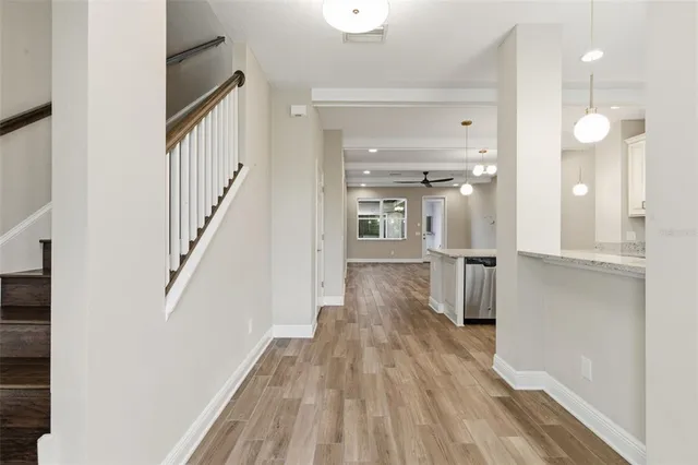 a view of a hallway with wooden floor and staircase