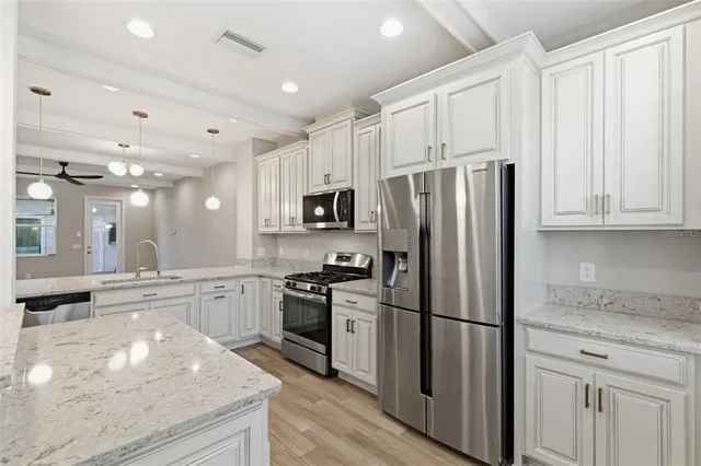 a kitchen with stainless steel appliances granite countertop a refrigerator stove and sink