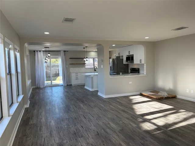 a view of a kitchen with wooden floor and a kitchen