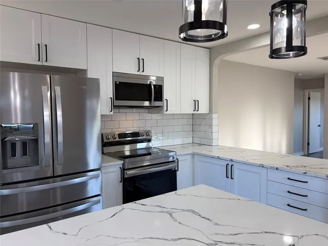 a kitchen with stainless steel appliances a refrigerator sink and microwave