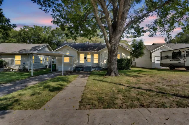 a front view of a house with a yard and trees