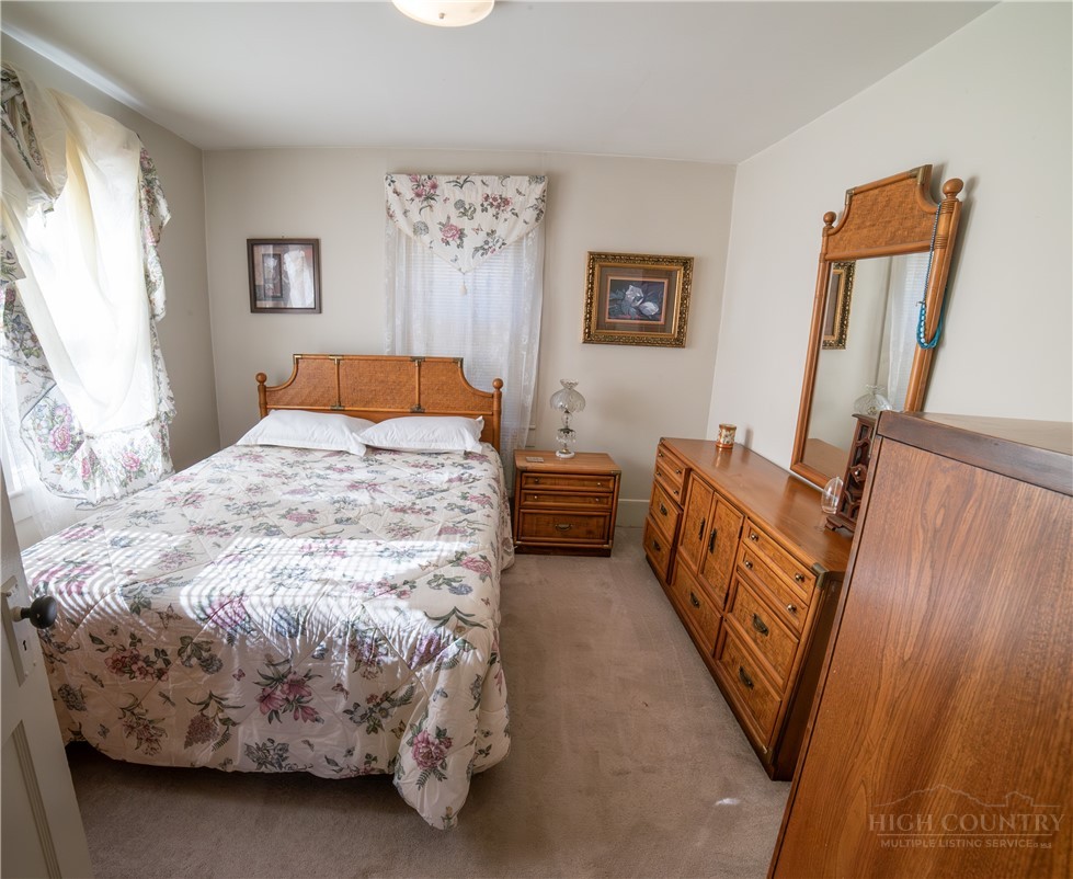 292 Little Elk Road Elk Park, NC 28622 - Photo 22 of 28 a bedroom with bed and a large mirror on the dresser
