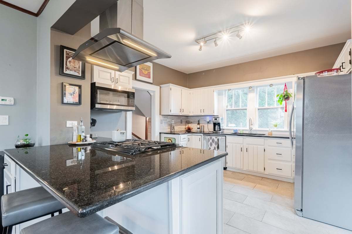 412 West Virginia Avenue Normal, IL 61761 - Photo 11 of 42 a kitchen with granite countertop a sink a counter top space appliances and cabinets