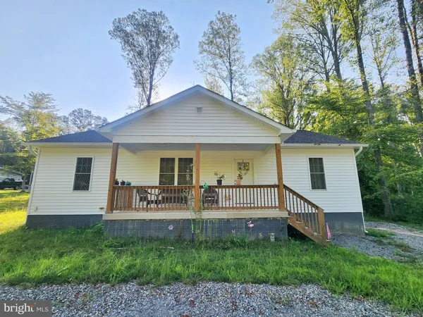 a view of a house with a yard porch and furniture