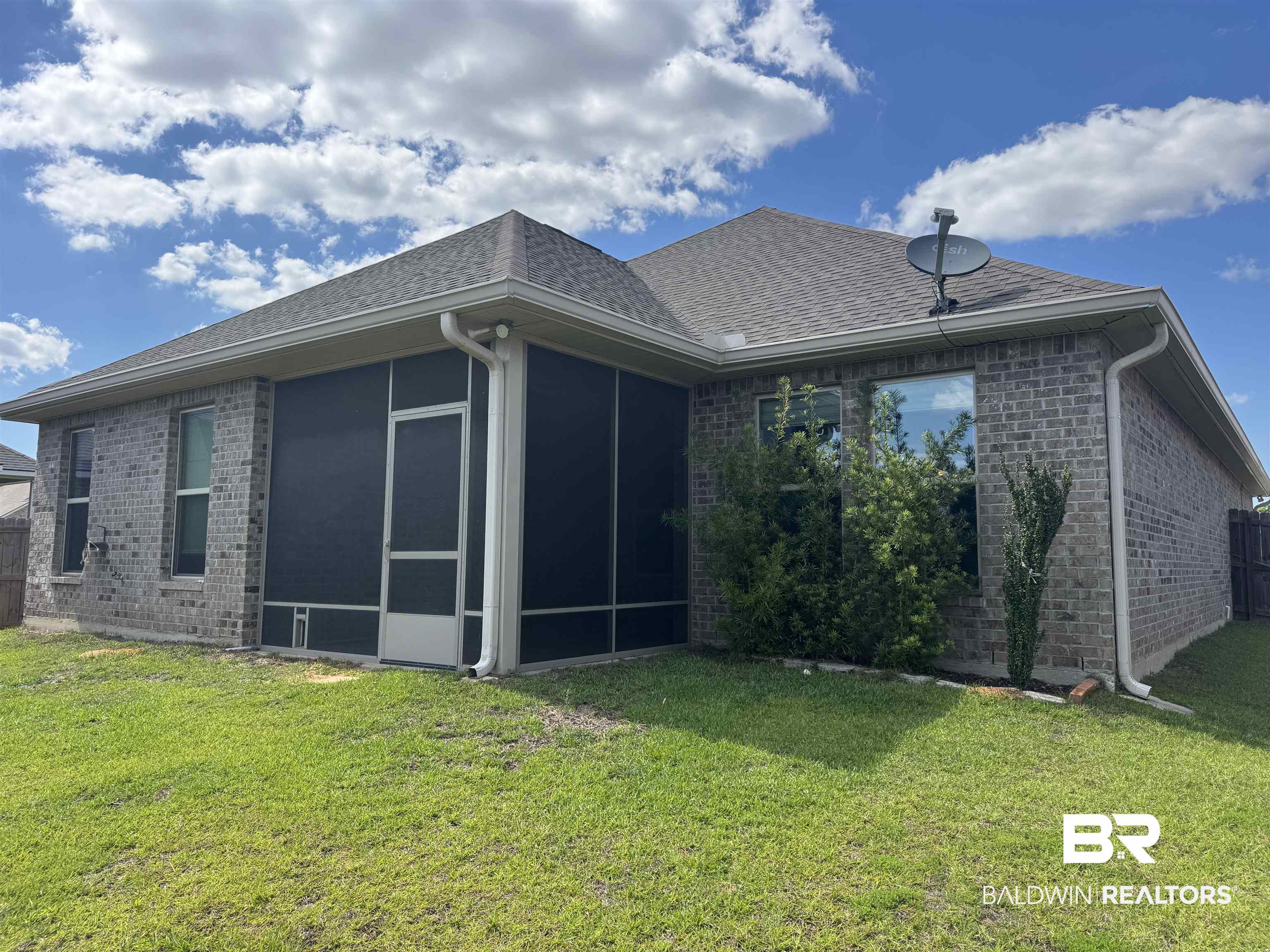 1060 Chloe Street Foley, AL 36535 - Photo 4 of 28 Brick exterior featuring a screened-in porch with an access door, white gutters, and a shingled roof