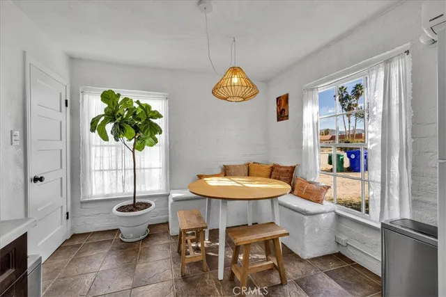 a dining room with furniture and a potted plant