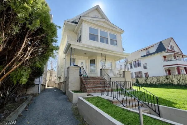 a view of a house with wooden fence and a yard