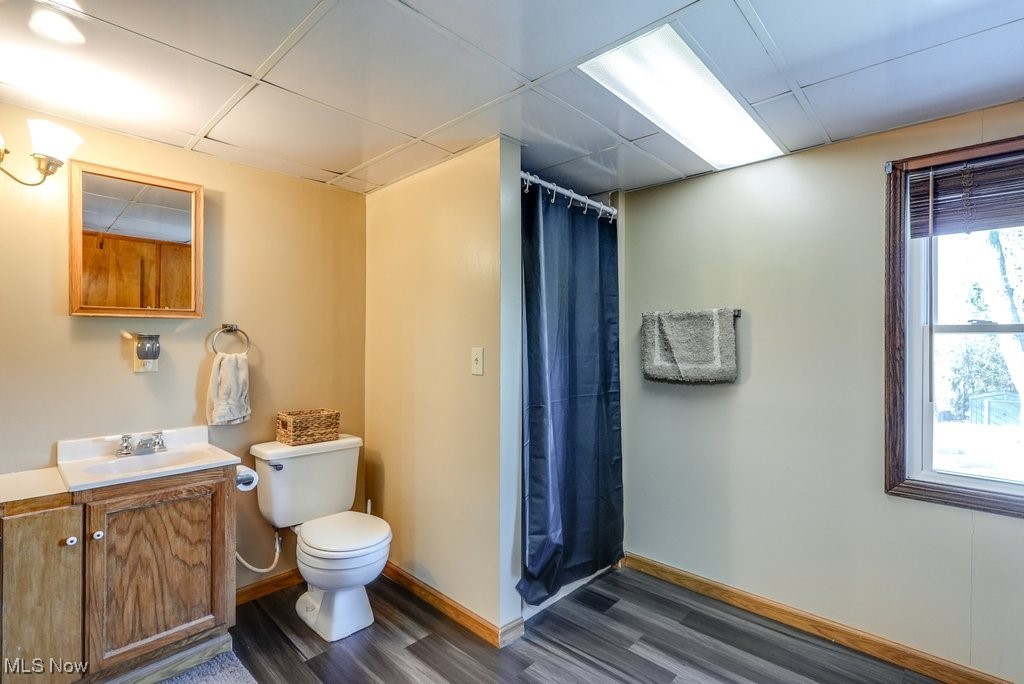 1157 Bass Circle Northwest Canton, OH 44708 - Photo 22 of 31 Bathroom featuring vanity, wood finished floors, baseboards, a drop ceiling, and toilet