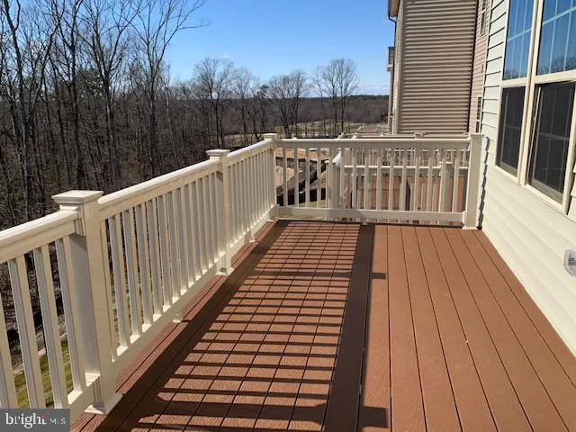 a view of balcony with wooden floor and fence