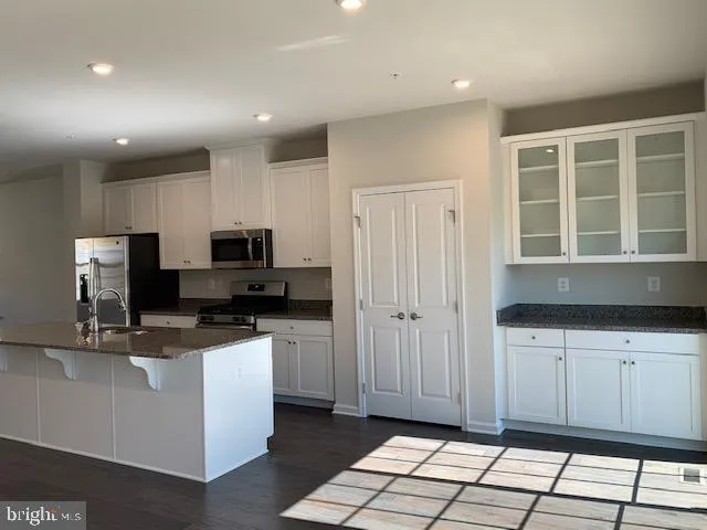a kitchen with stainless steel appliances granite countertop a sink and a stove