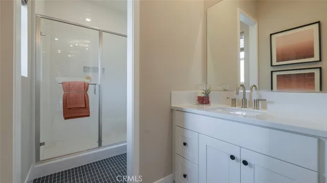 a bathroom with a sink a mirror a shower and vanity