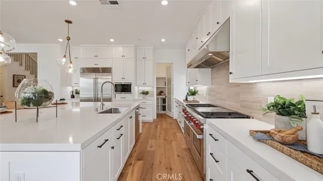 a kitchen with stainless steel appliances a sink a stove and a wooden floors
