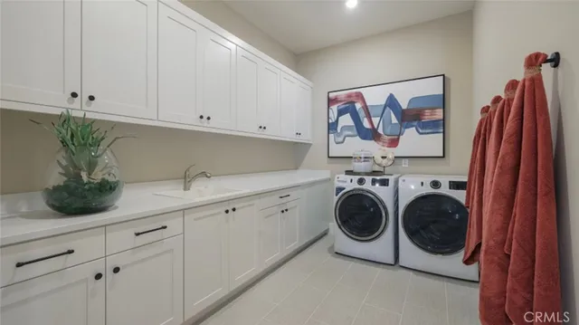 a utility room with sink dryer and washer