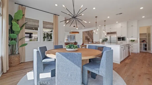 a open kitchen with stainless steel appliances granite countertop a stove refrigerator dining table and chairs