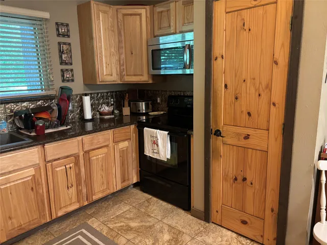 a kitchen with stainless steel appliances granite countertop a refrigerator and cabinets