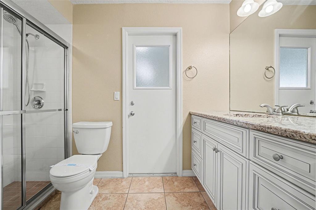 122 Costa Loop Auburndale, FL 33823 - Photo 11 of 30 a bathroom with a granite countertop toilet a sink and a mirror