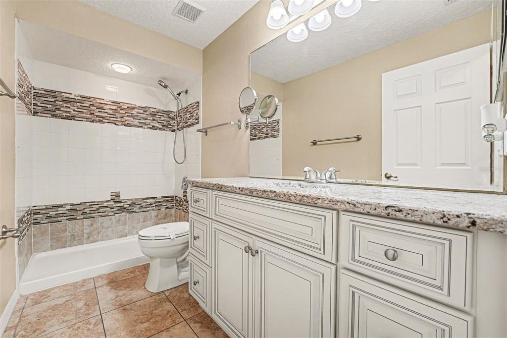 122 Costa Loop Auburndale, FL 33823 - Photo 19 of 30 a spacious bathroom with a granite countertop sink a toilet and a bathtub