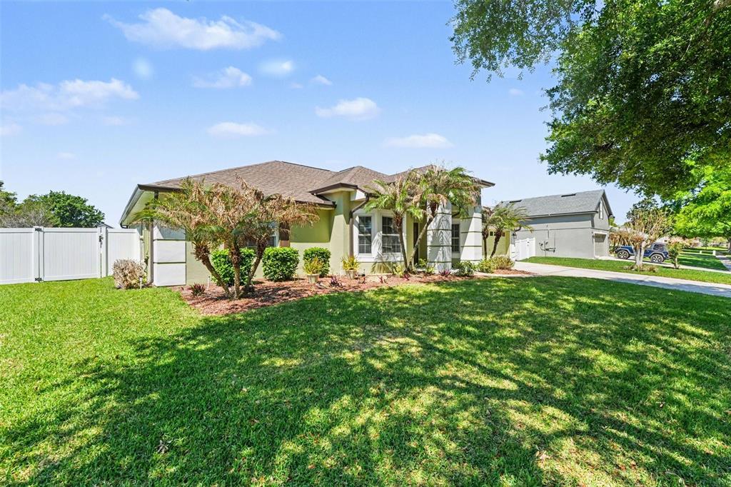 122 Costa Loop Auburndale, FL 33823 - Photo 2 of 30 a view of a house with a big yard potted plants and large tree